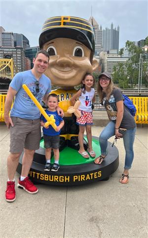 Ms. Meleo and her family pose with a bobblehead doll at PNC Park in Pittsburgh.